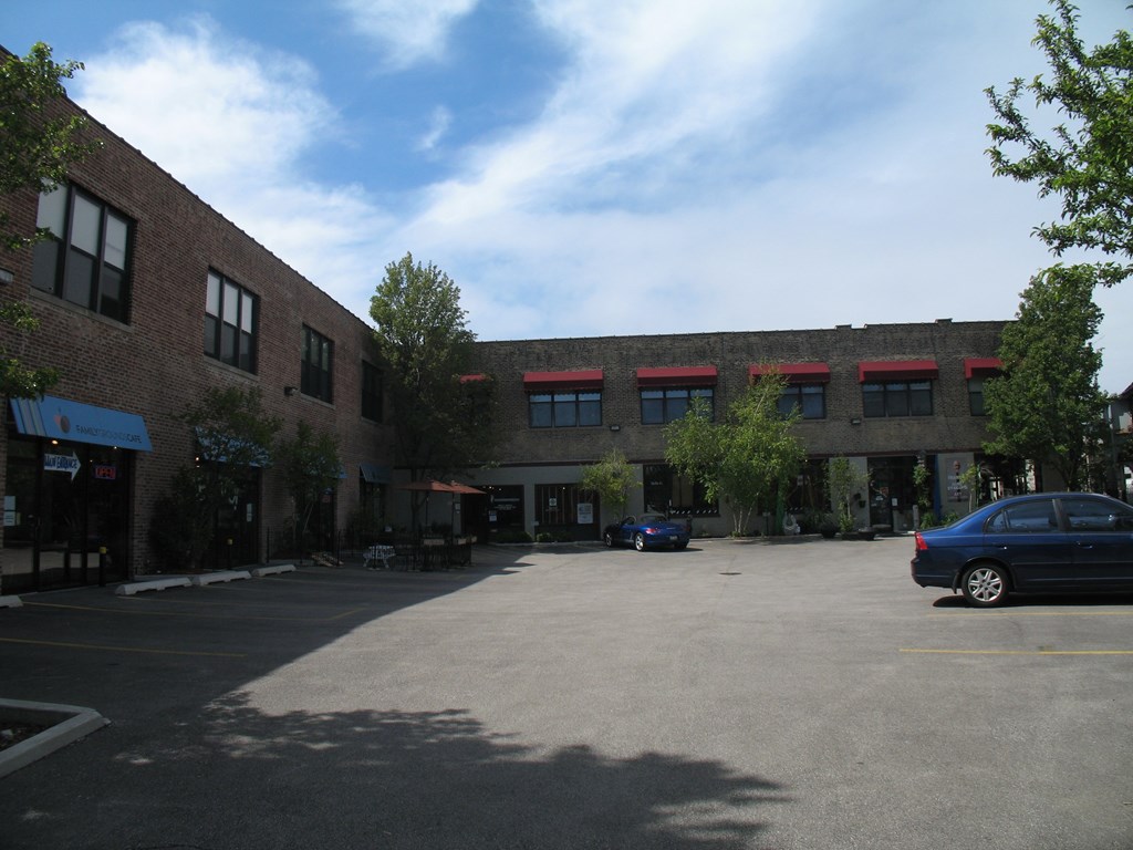 an empty parking lot in front of a brick building