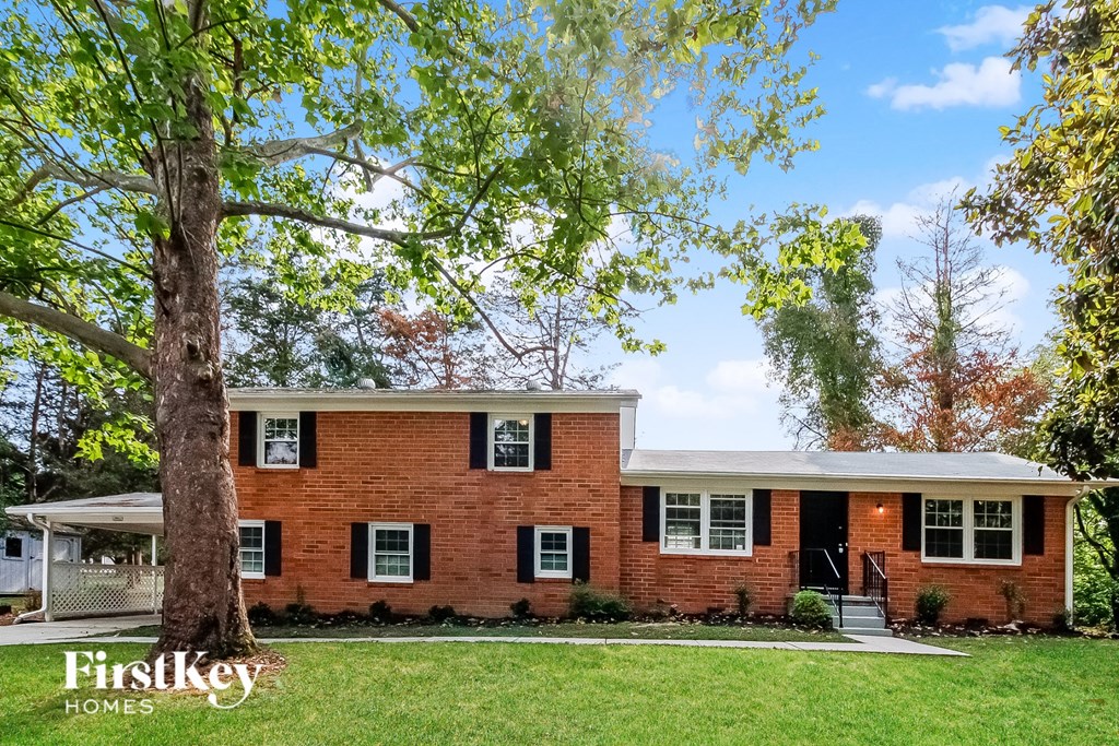 a red brick house with a tree in front of it