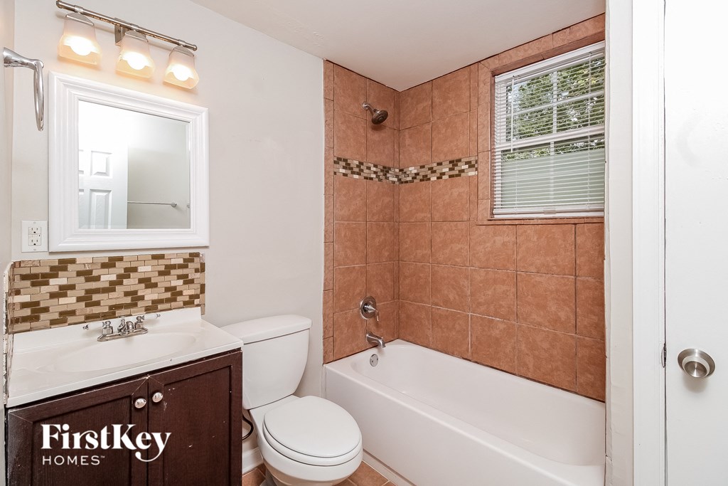 a bathroom with a toilet and a tub and a sink