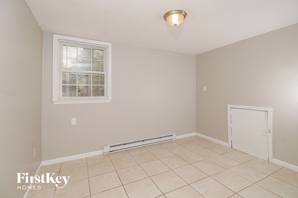 the living room of a house with a tiled floor and a white door