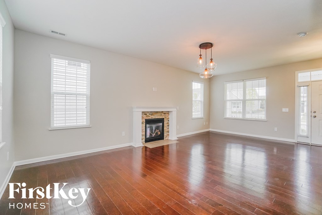 an empty living room with wood floors and a fireplace