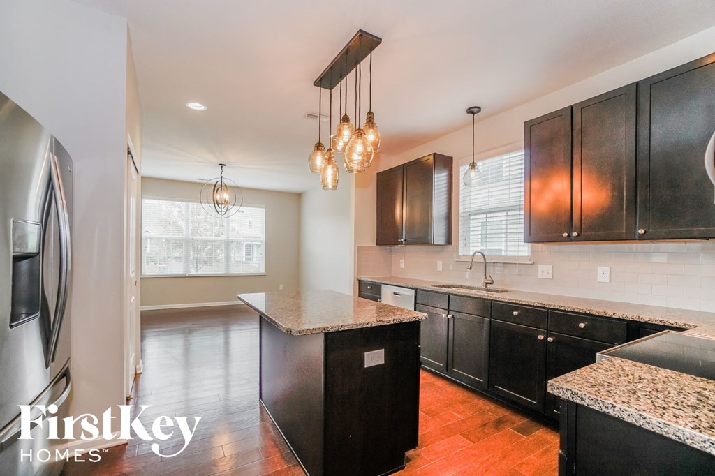 a kitchen with black cabinets and stainless steel appliances