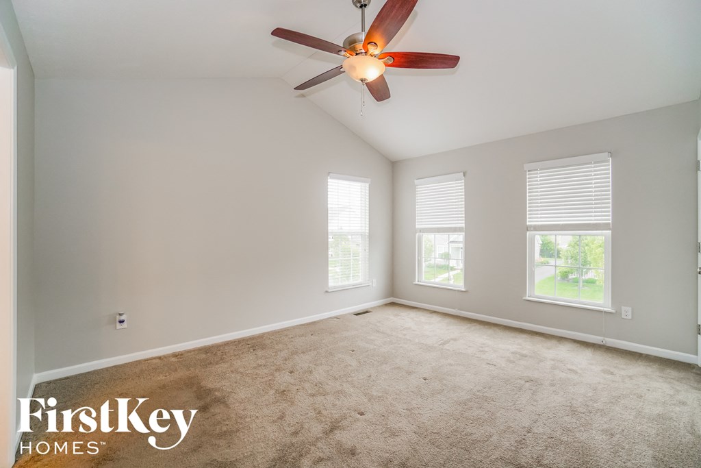 a living room with carpet and a ceiling fan