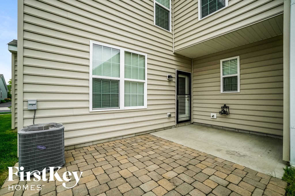 the front of a house with a patio and a garbage can