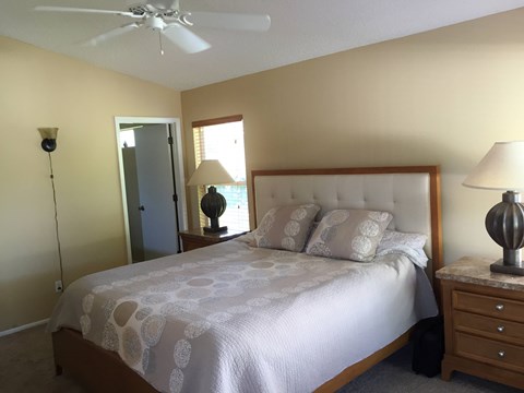 A bedroom with a bed, nightstand, and lamp.