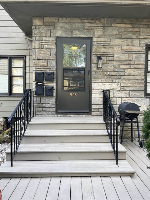 the front door of a house with stairs and a porch