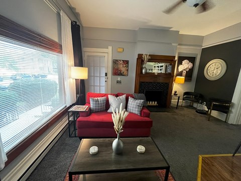a living room with a red couch and a large window