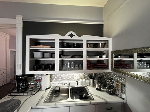 a kitchen with a sink and some open cabinets