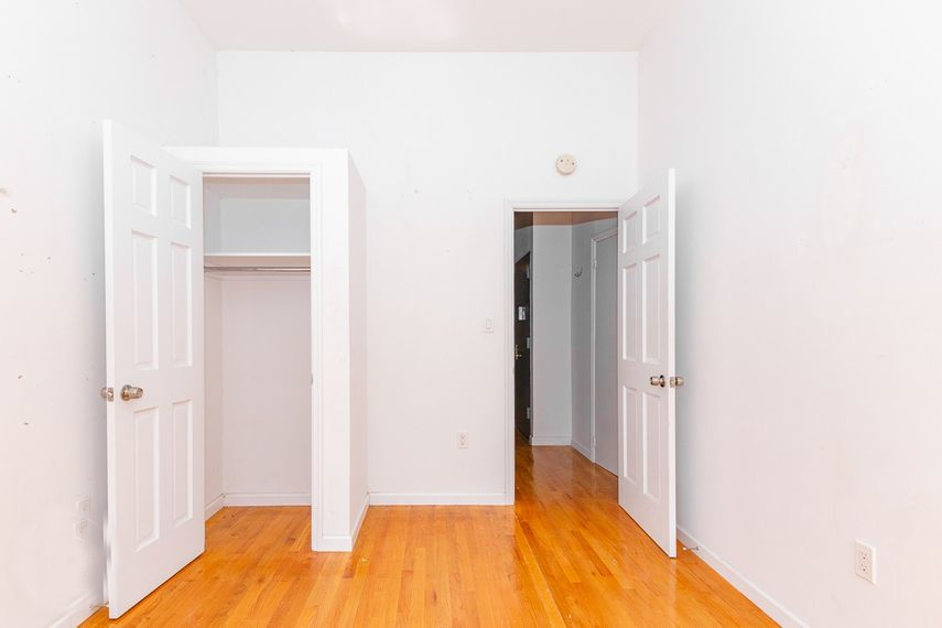 an empty room with three doors and a wood floor