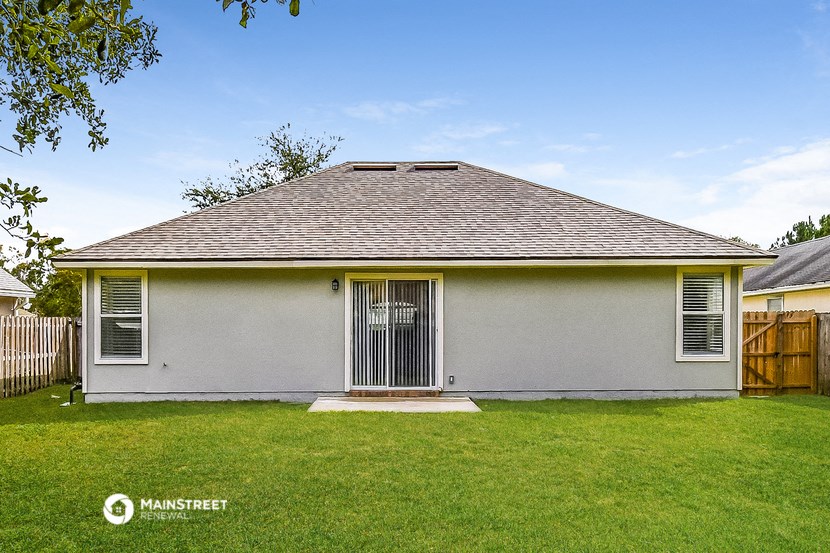 a white house with a yard and a wood fence