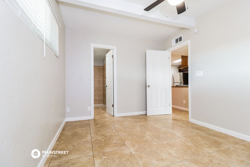 a living room with a door to a bathroom and a closet