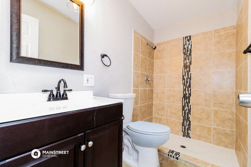 a bathroom with a toilet and a sink and a shower