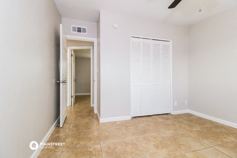 an empty room with a closet and a door to a hallway