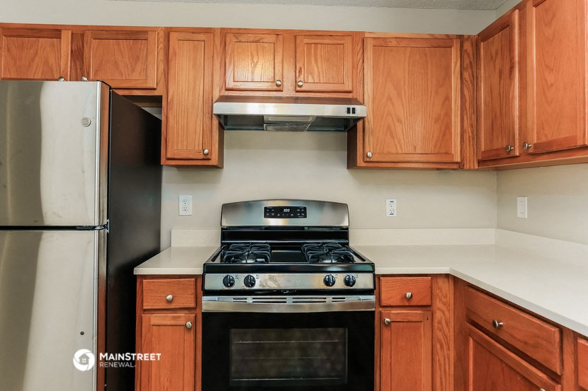 a kitchen with wooden cabinets and a stove and a refrigerator