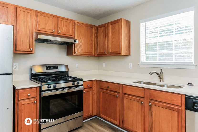 a kitchen with wooden cabinets and a stove and a sink