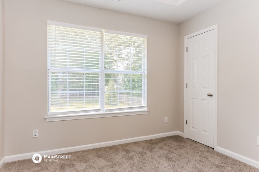 a bedroom with a large window and a white door