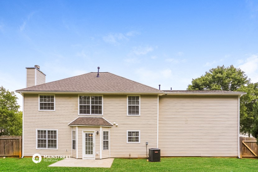 a white house with a brown roof and a yard