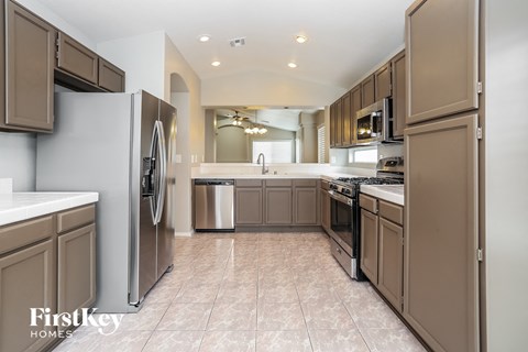 A kitchen with brown cabinets and a refrigerator.
