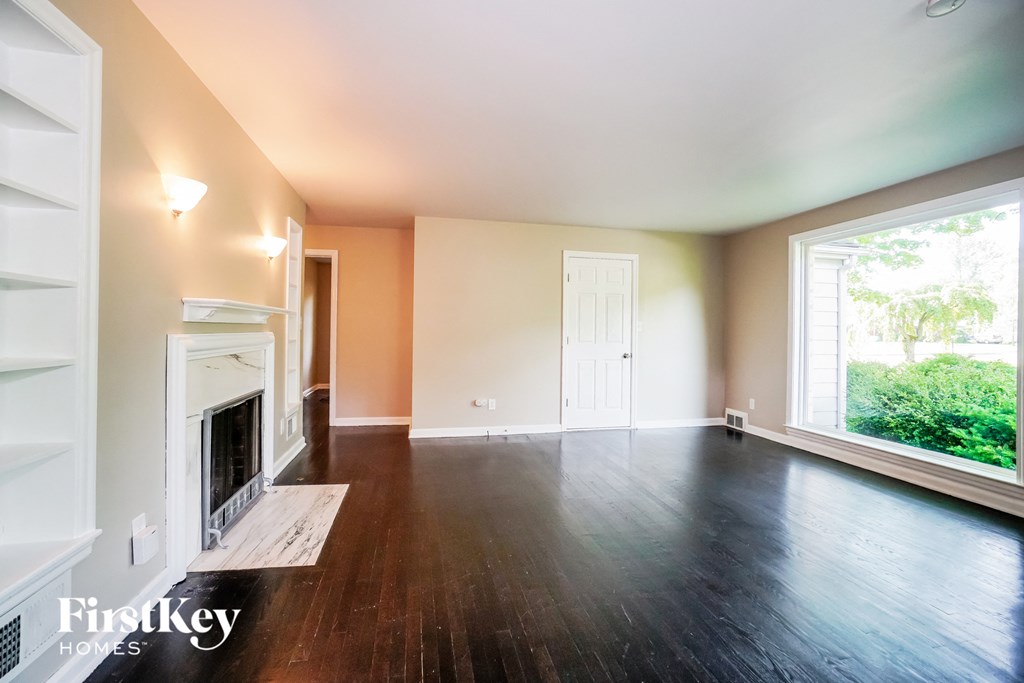 an empty living room with a fireplace and a large window