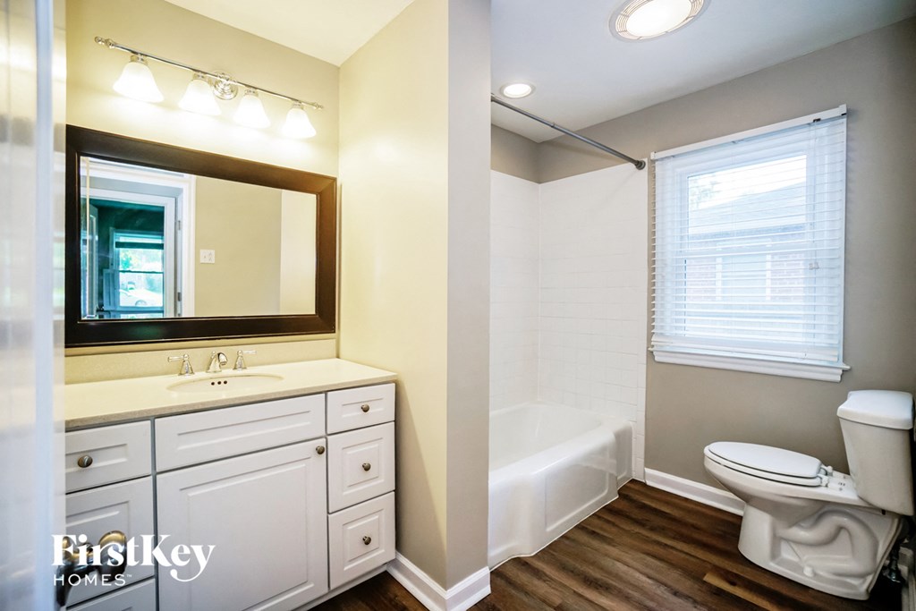 a bathroom with a toilet sink and tub and a mirror