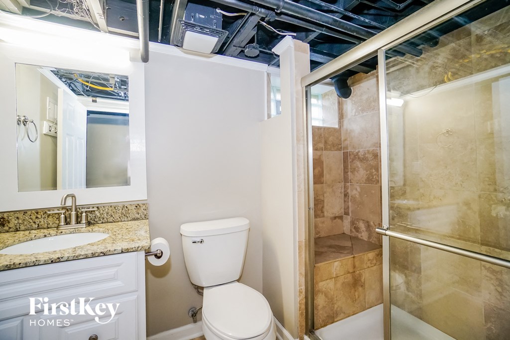 a bathroom with a toilet and a shower and a sink