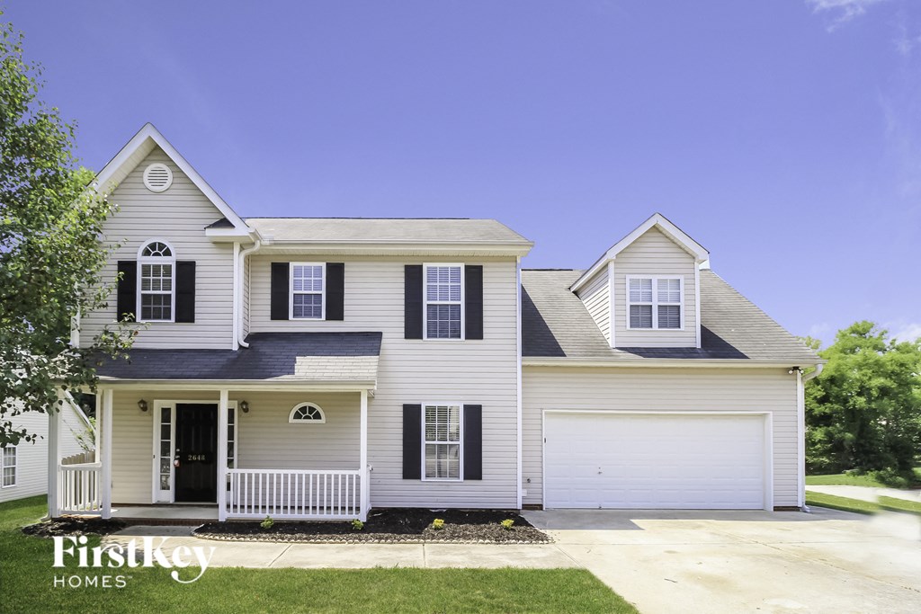 A two-story house with a white garage door and black shutters.