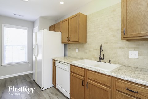 A kitchen with wooden cabinets and a white fridge.
