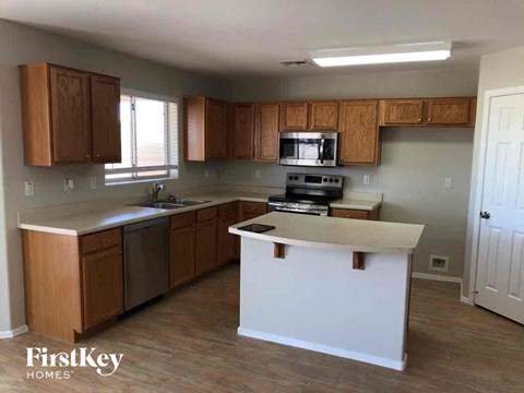 A kitchen with wooden cabinets and a white island.
