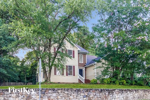 a house with a stone wall and trees