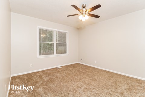 a bedroom with carpet and a ceiling fan