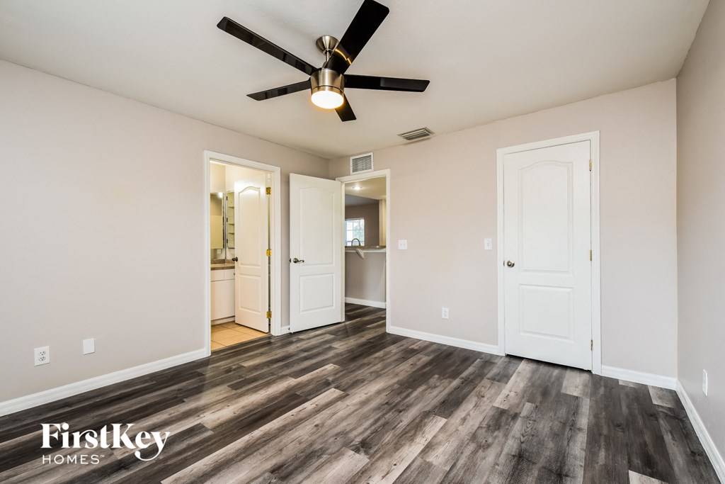 a living room with wood floors and a ceiling fan