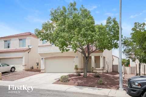 a house with a tree in front of a driveway