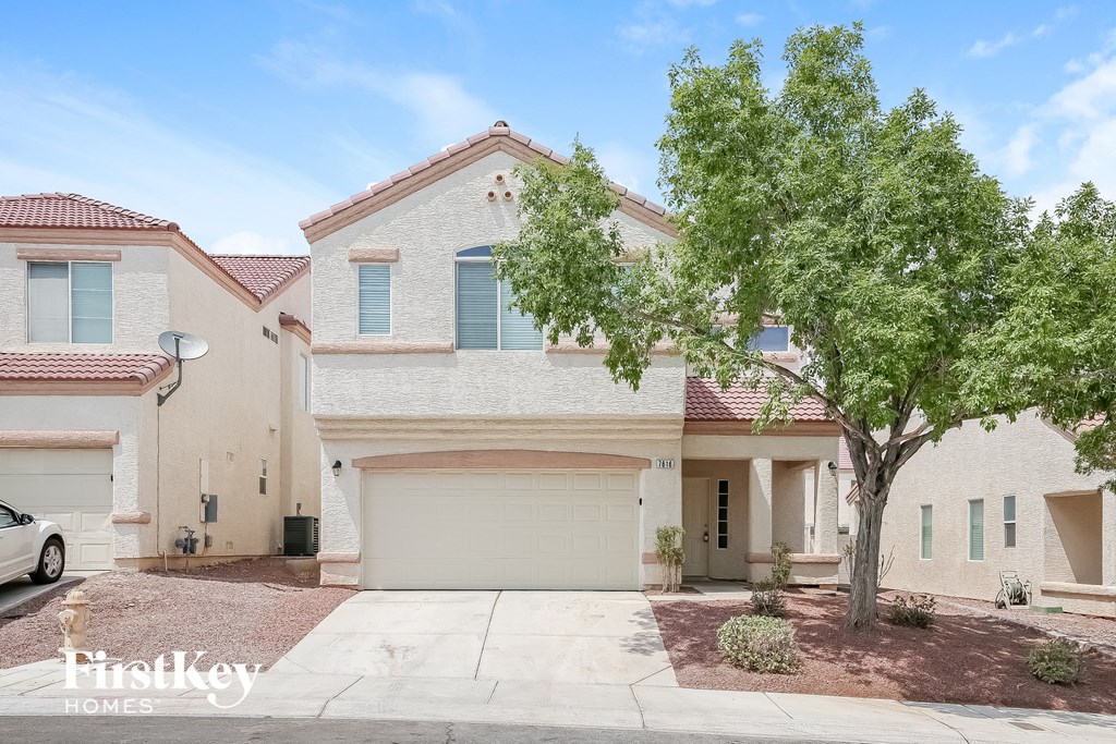 a white house with a tree in front of it