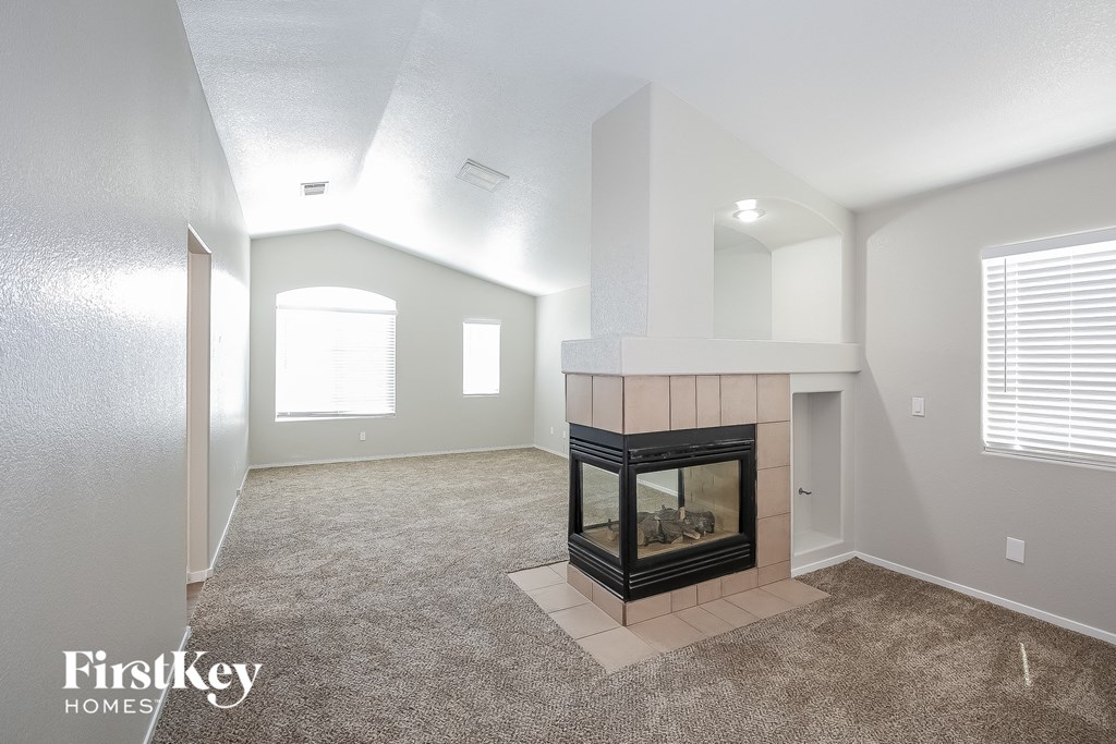 the living room has a fireplace and carpeted flooring