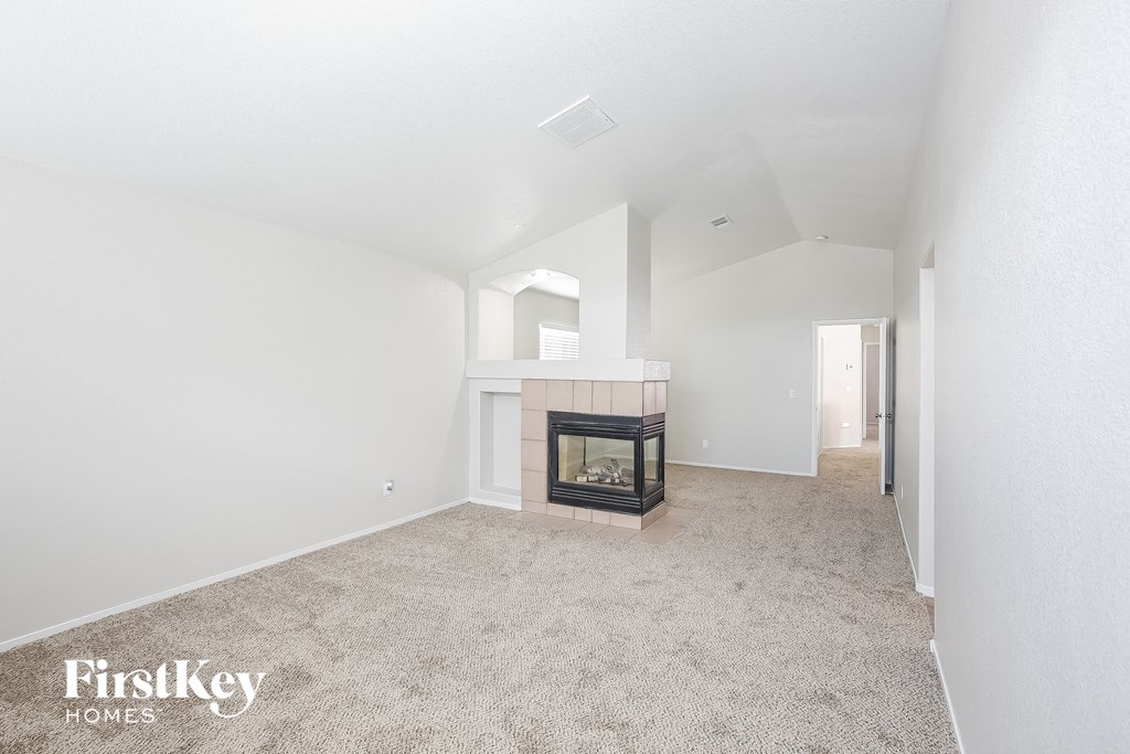 a living room with a fireplace and a carpeted floor