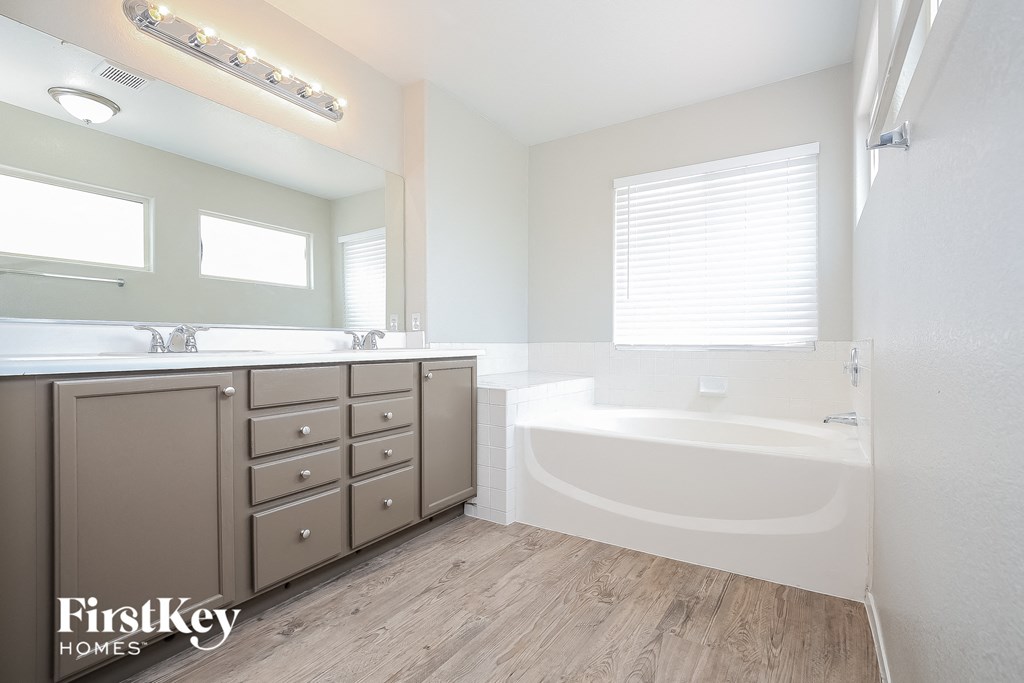 a bathroom with a tub and a sink and a mirror