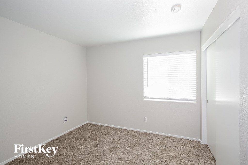 a bedroom with a carpeted floor and a window