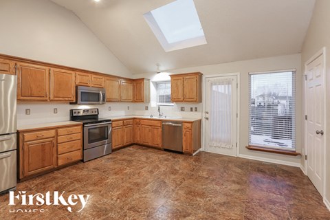 A kitchen with wooden cabinets and a skylight.