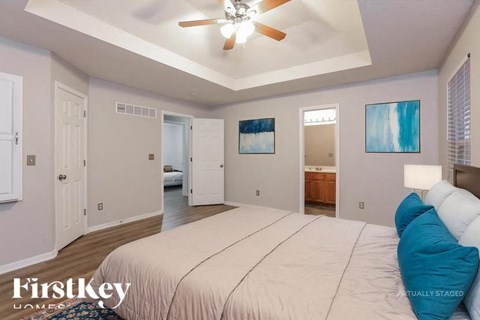 A bedroom with a large bed and a ceiling fan.