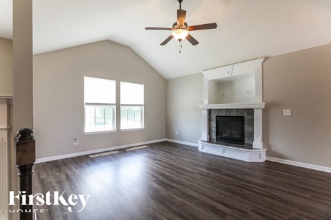 a living room with a fireplace and a ceiling fan