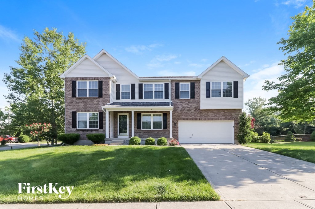 a brick house with a white garage door and a lawn