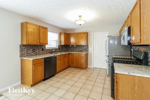 a kitchen with wooden cabinets and a stove and refrigerator