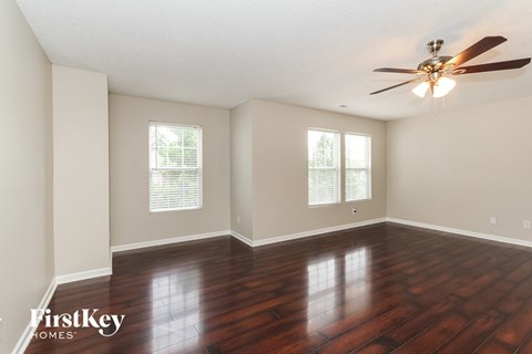 the living room with hardwood floors and a ceiling fan