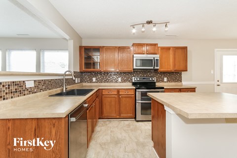 a kitchen with wooden cabinets and a white counter top