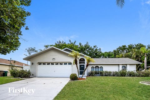 a white house with a white garage door and a lawn