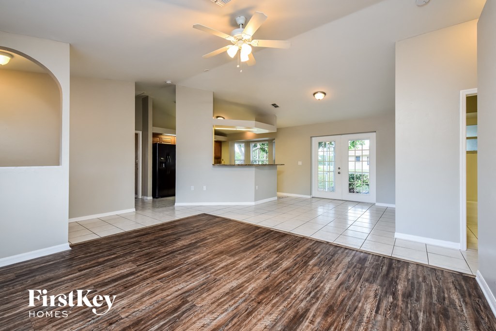 an empty living room with a ceiling fan