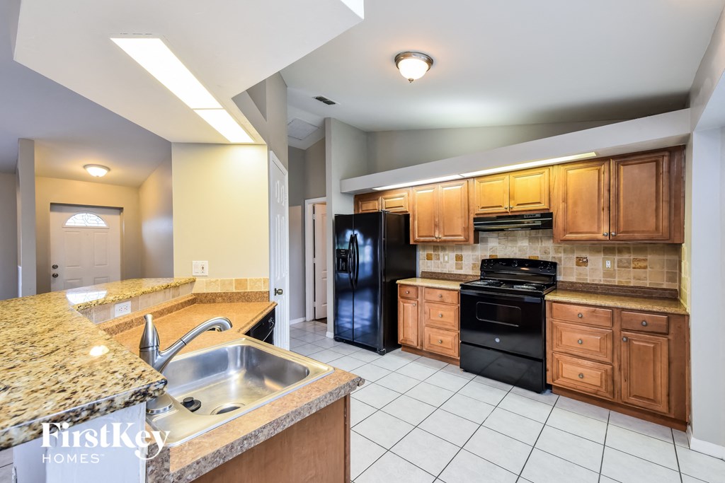 a kitchen with black appliances and granite counter tops