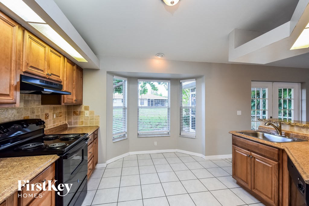 a kitchen with wooden cabinets and a black stove and a sink