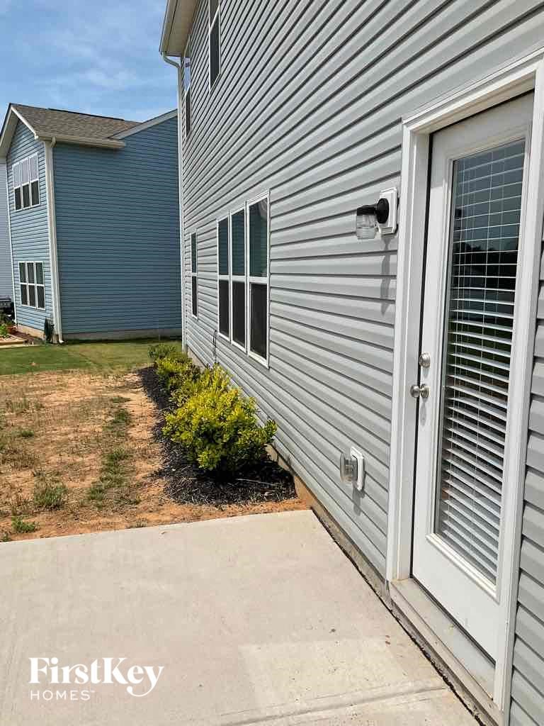a side view of a house with a sidewalk and a door