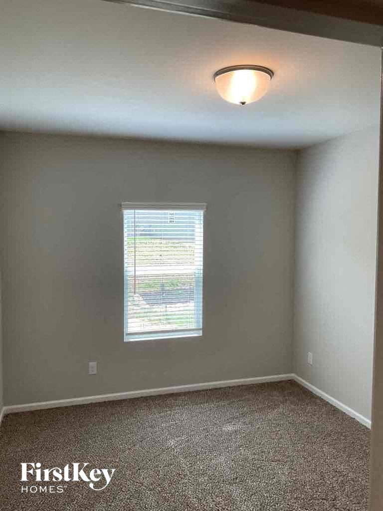 an empty room with a window and a light on the ceiling